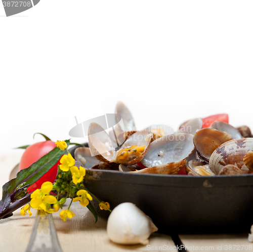 Image of fresh clams on an iron skillet