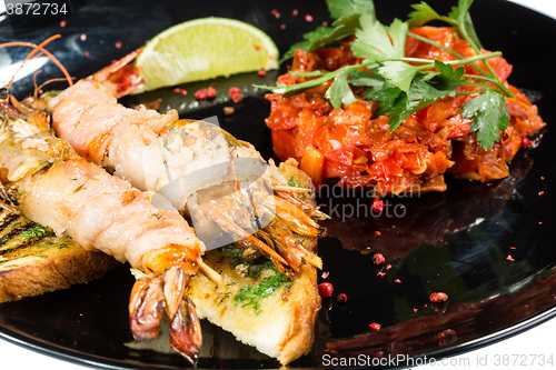 Image of perfect dish with shrimps on a black plate. seafood