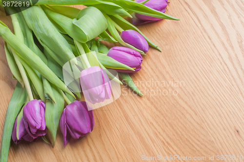 Image of Violet tulips, cake and tea on the wood