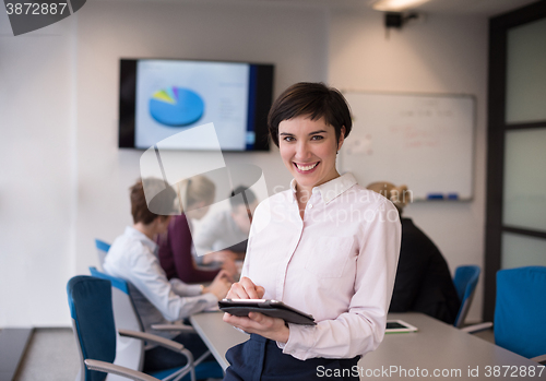 Image of hispanic businesswoman with tablet at meeting room