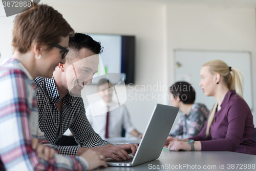 Image of young business couple working on laptop, businesspeople group on