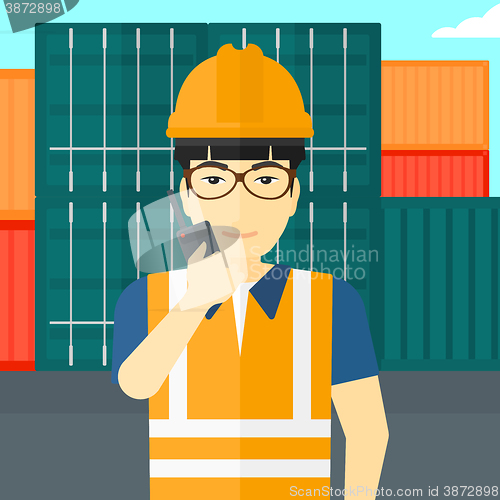 Image of Stevedore standing on cargo containers background.