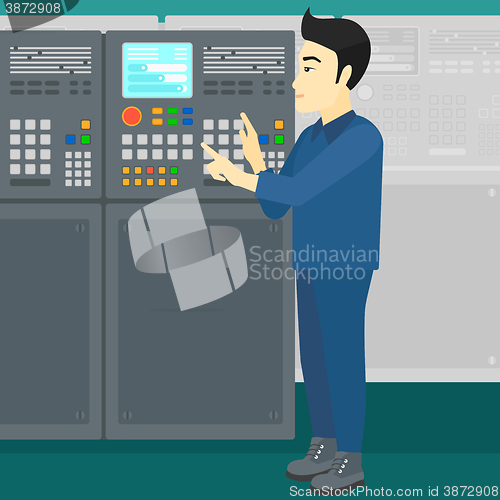 Image of Engineer standing near control panel.
