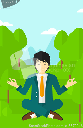 Image of Businessman meditating in lotus pose.