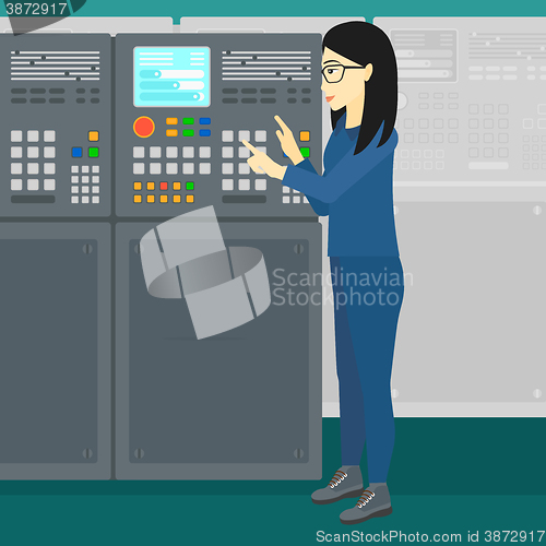 Image of Engineer standing near control panel.