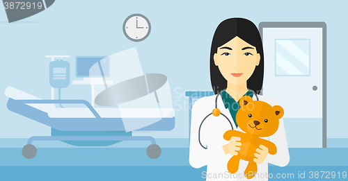 Image of Pediatrician holding teddy bear.