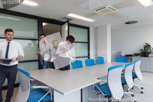 Image of business people group entering meeting room, motion blur