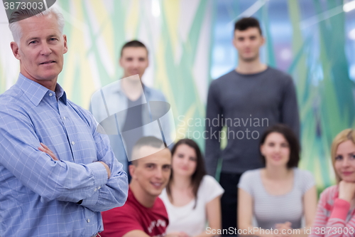 Image of portrait of  teacher with students group in background