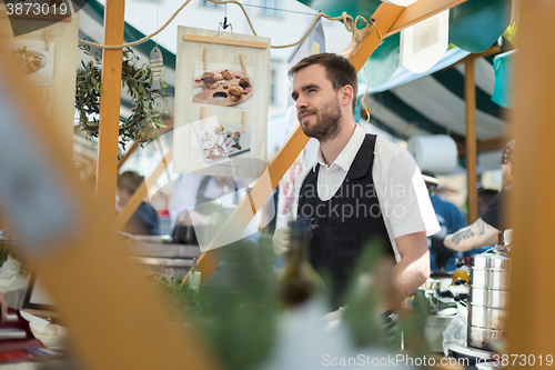 Image of Man serving street food on international cuisine event in Ljubljana, Slovenia.