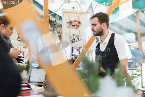 Image of Man serving street food on international cuisine event in Ljubljana, Slovenia.