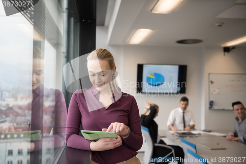 Image of blonde businesswoman working on tablet at office