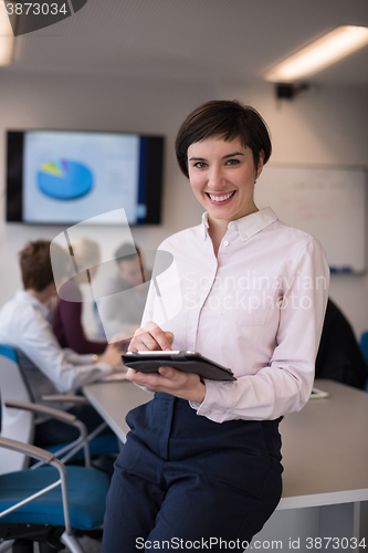 Image of hispanic businesswoman with tablet at meeting room