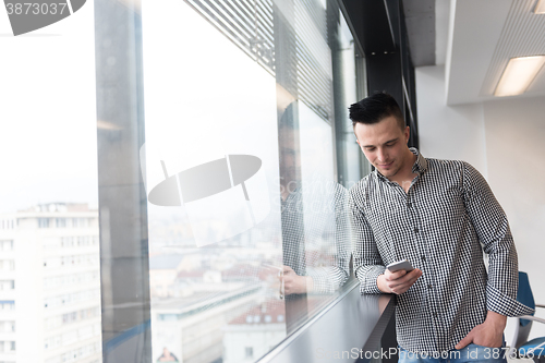 Image of young business man using smart phone at office