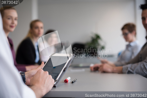 Image of close up of  businessman hands  using tablet on meeting