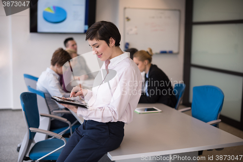 Image of hispanic businesswoman with tablet at meeting room