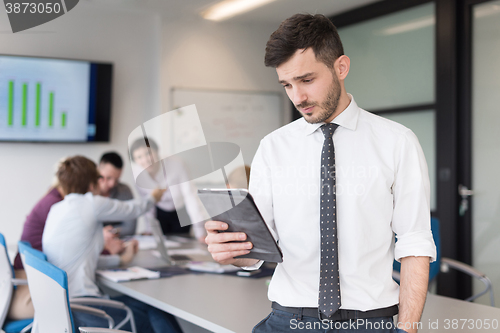 Image of young business man with tablet at office meeting room
