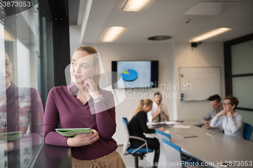 Image of blonde businesswoman working on tablet at office