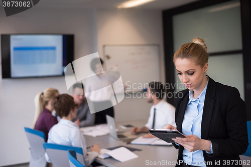 Image of business woman working on tablet at meeting room