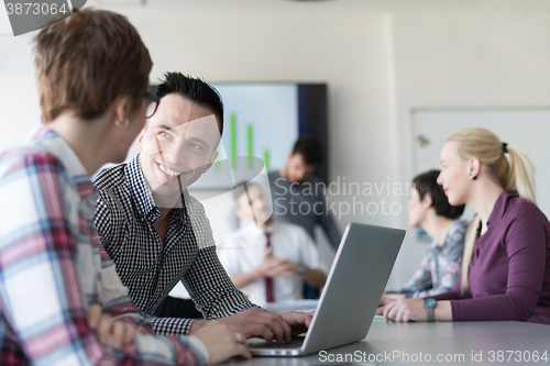 Image of young business couple working on laptop, businesspeople group on
