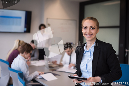 Image of business woman working on tablet at meeting room
