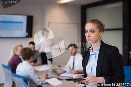 Image of business woman working on tablet at meeting room