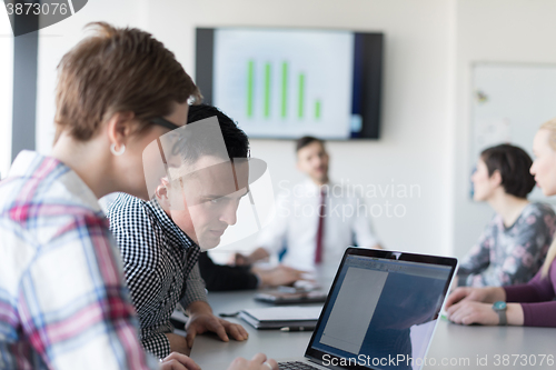 Image of young business couple working on laptop, businesspeople group on