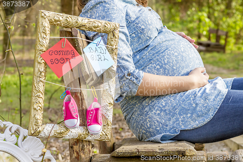 Image of pregnant woman outdoor in the park on banch