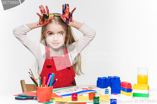 Image of The beautiful little girl with hands in the paint