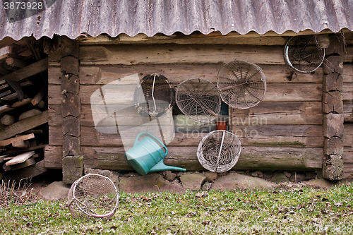 Image of Old grunge wooden house wall with agricultural implements