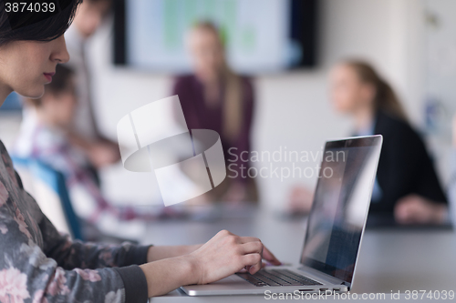 Image of young business woman at office working on laptop with team on me