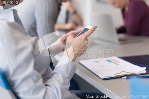 Image of close up of  busineswoman hands  using smart phone on meeting