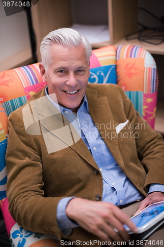 Image of portrait of handsome teacher in colorful chair