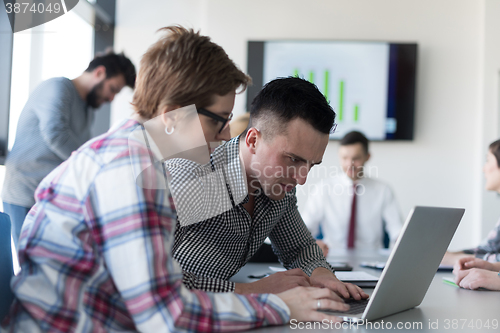 Image of young business couple working on laptop, businesspeople group on