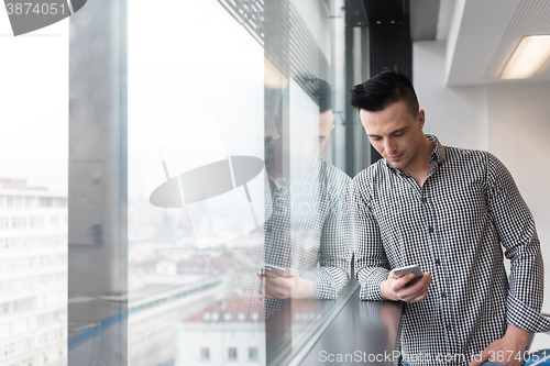 Image of young business man using smart phone at office