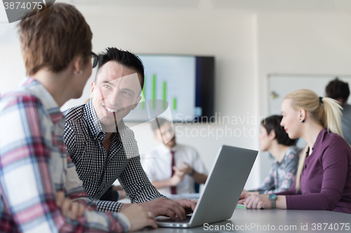 Image of young business couple working on laptop, businesspeople group on