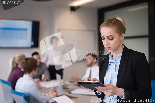 Image of business woman working on tablet at meeting room