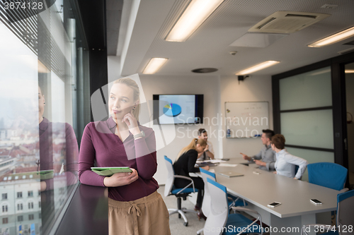 Image of blonde businesswoman working on tablet at office