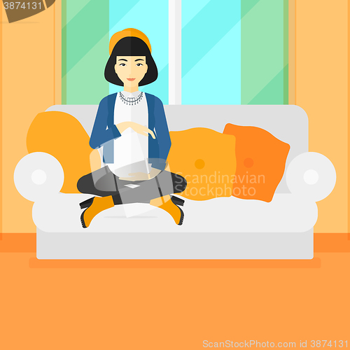 Image of Pregnant woman sitting on sofa.