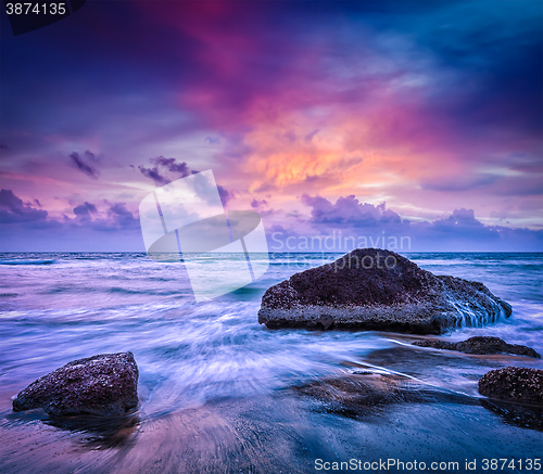 Image of Waves and rocks on beach of sunset