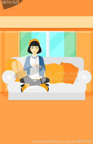 Image of Pregnant woman sitting on sofa.