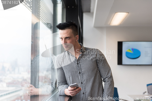 Image of young business man using smart phone at office