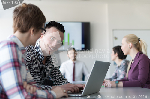 Image of young business couple working on laptop, businesspeople group on