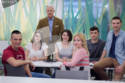 Image of portrait of  teacher with students group in background