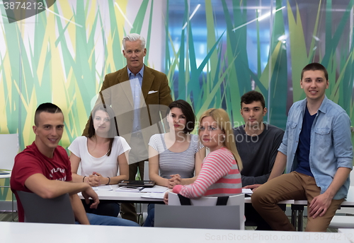 Image of portrait of  teacher with students group in background