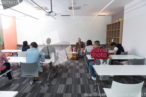 Image of teacher with a group of students in classroom