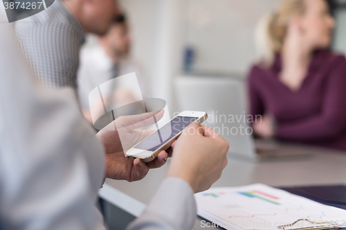 Image of close up of  busineswoman hands  using smart phone on meeting