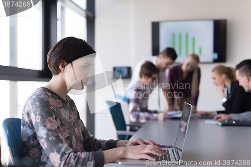 Image of young business woman at office working on laptop with team on me