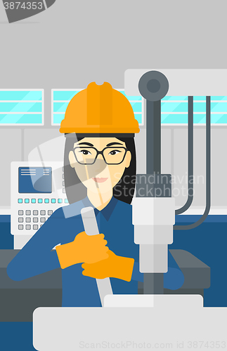 Image of Woman working with industrial equipment.