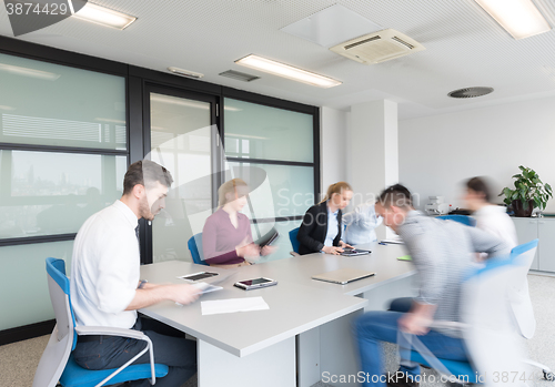 Image of business people group entering meeting room, motion blur