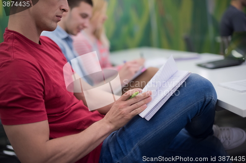 Image of male student taking notes in classroom